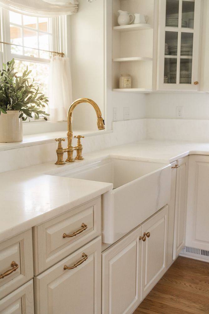 Apron-front sink with brass faucet and marble countertop